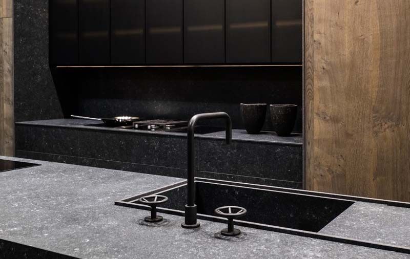 Una cocina con un fregadero negro y un grifo negro.