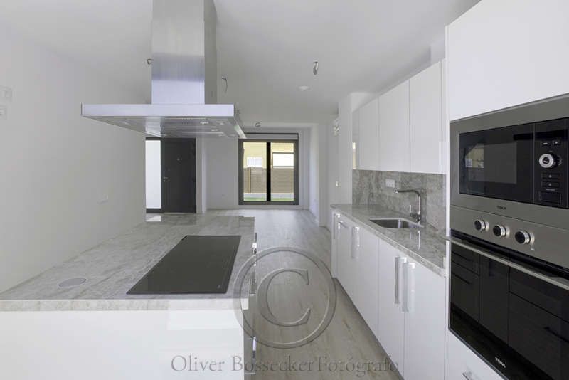 Una cocina con gabinetes blancos y electrodomésticos de acero inoxidable.