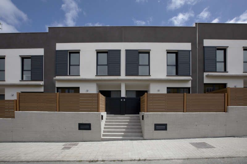 Una hilera de casas con una valla de madera alrededor de ellas.