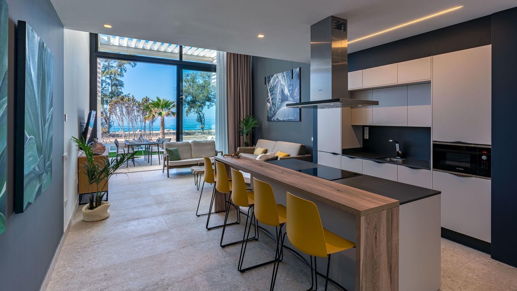 Una cocina moderna con una gran isla y sillas amarillas.