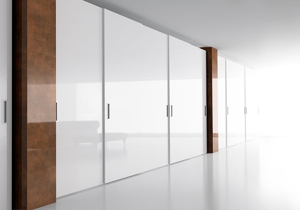 Un largo pasillo con puertas blancas y un pilar de madera.