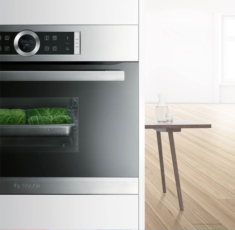 Un horno de acero inoxidable está situado al lado de una mesa de madera.