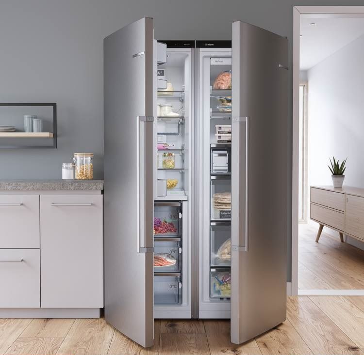 Un refrigerador de acero inoxidable con las puertas abiertas en una cocina.