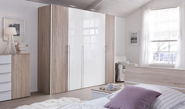 Un dormitorio con cama, cómoda, armario y ventana.
