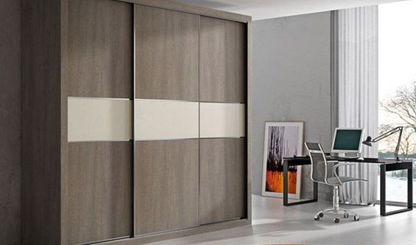 Un dormitorio con armario empotrado, escritorio, silla y ordenador.