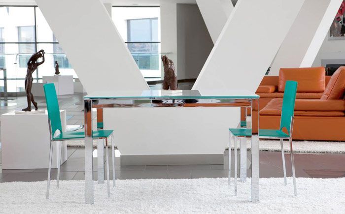 Una sala de estar con una mesa y sillas y un sofá naranja.