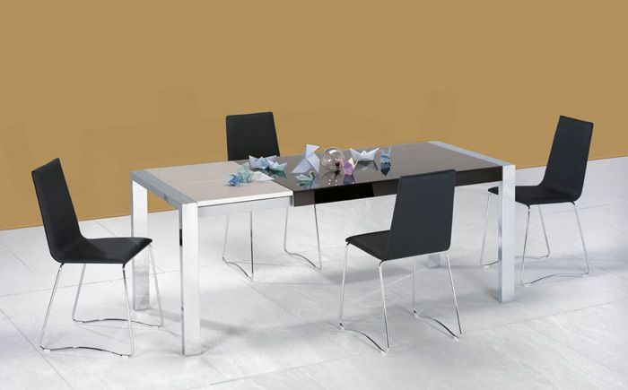 Una mesa de comedor con sillas negras frente a una pared marrón.