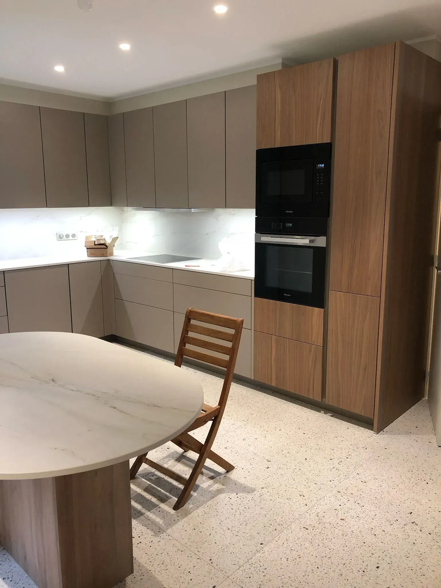 Cuisine de la gamme Poggenpohl en bois avec le plateau de la table en marbre