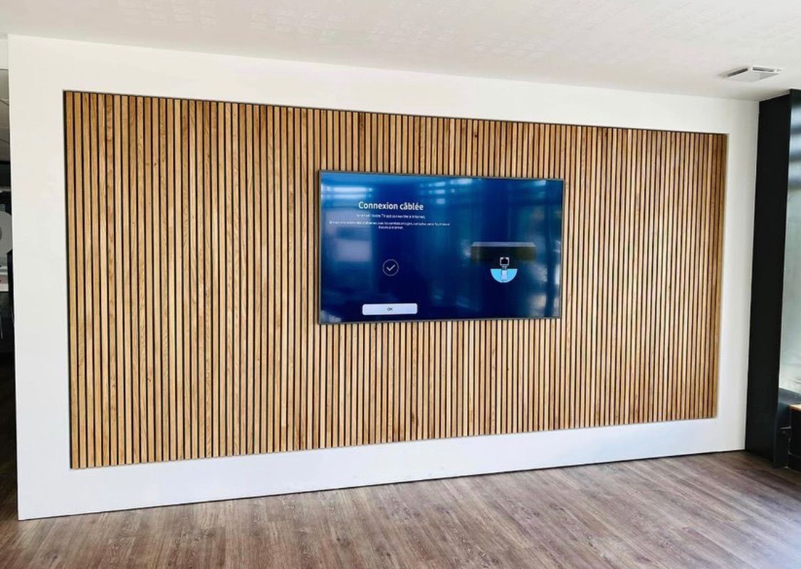 Téléviseur accroché à un mur avec habillage en bois