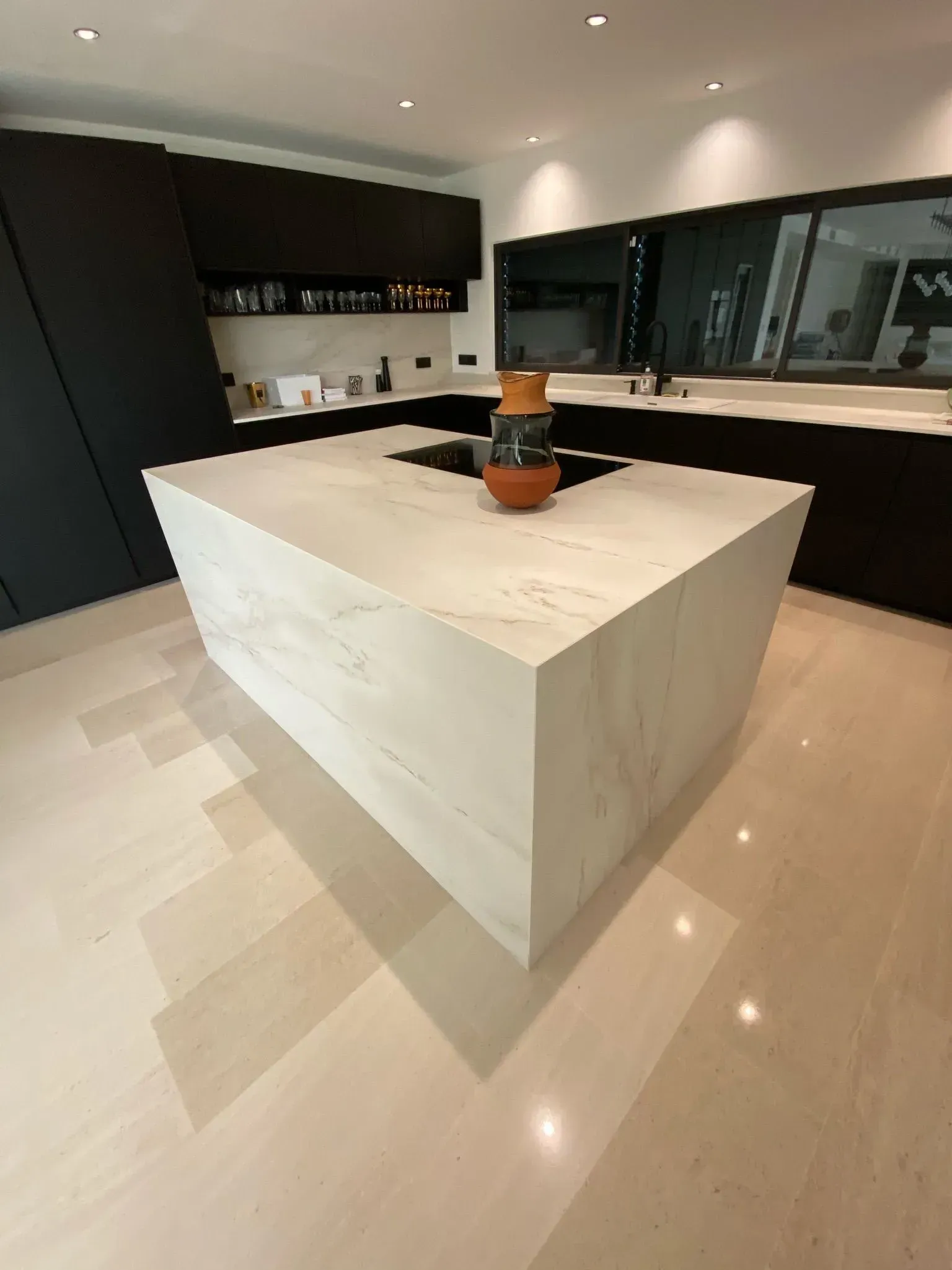 Cuisine Poggenpohl noir avec un îlot central en forme de cube