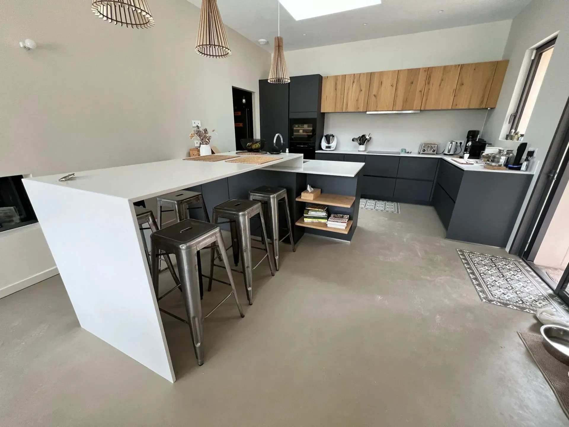 Cuisine Haecker de couleur gris anthracite et table haute blanche