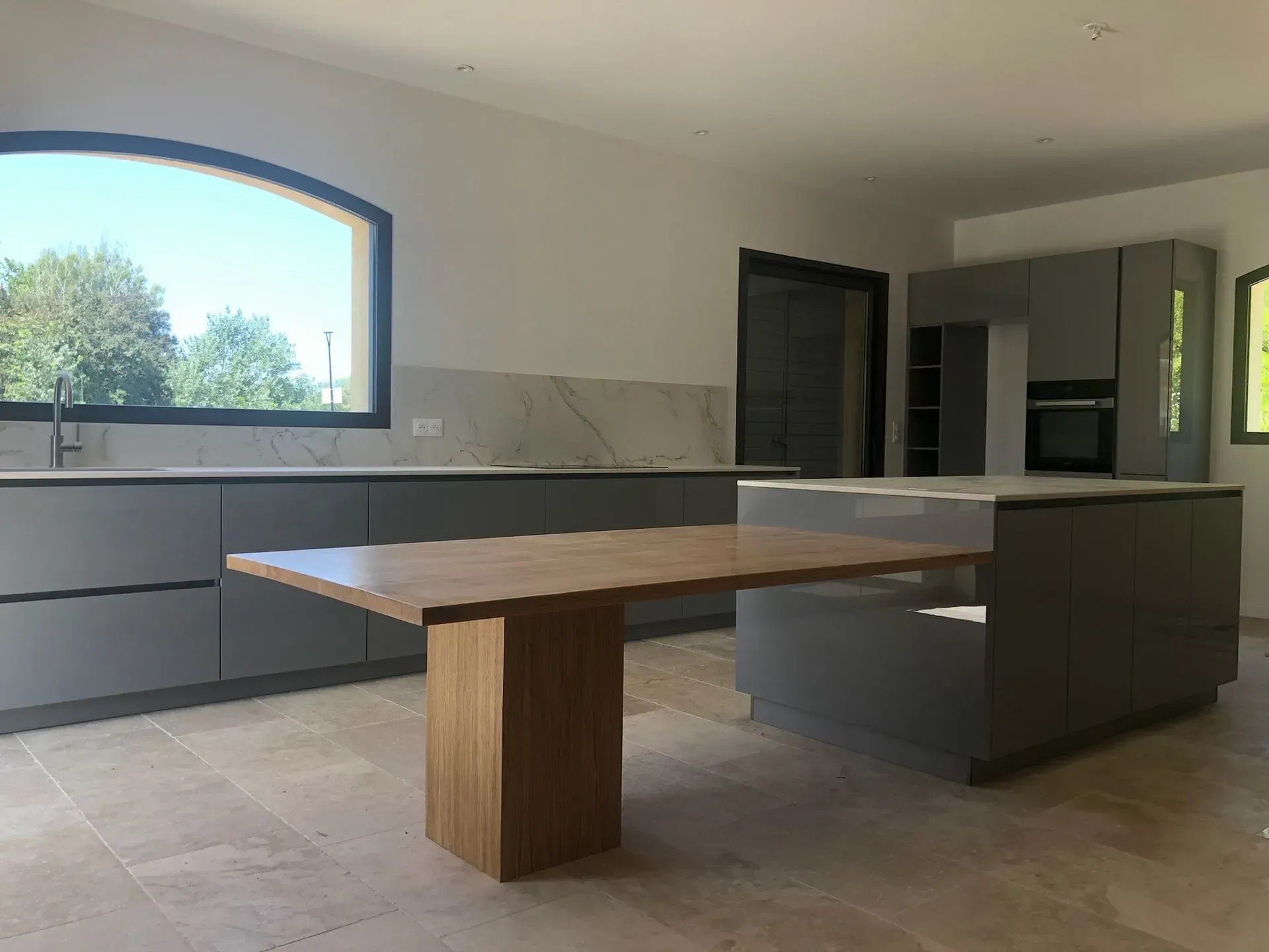 Cuisine grise avec un grand plan de travail de la marque Haecker