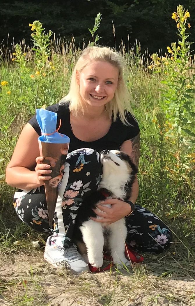 Eine Gruppe von Menschen posiert mit ihren Hunden für ein Foto.