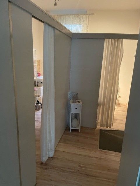 Ein Raum mit einer Schiebetür und einem weißen Vorhang