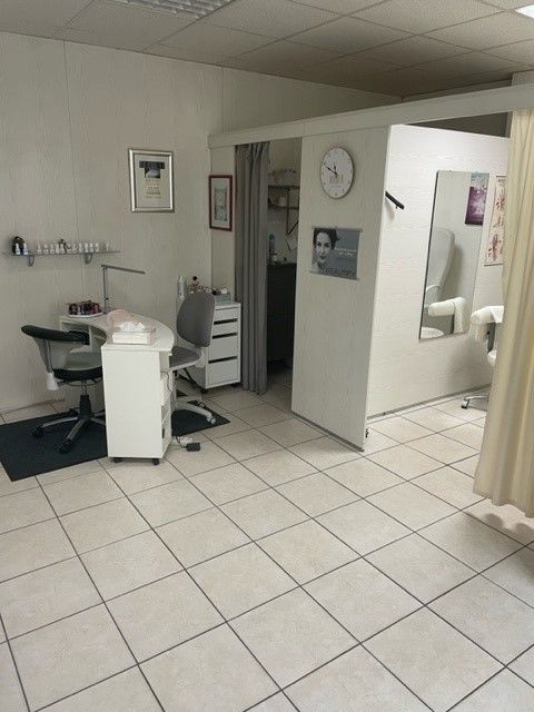 Ein Raum mit weißen Fliesenböden und einer Uhr an der Wand