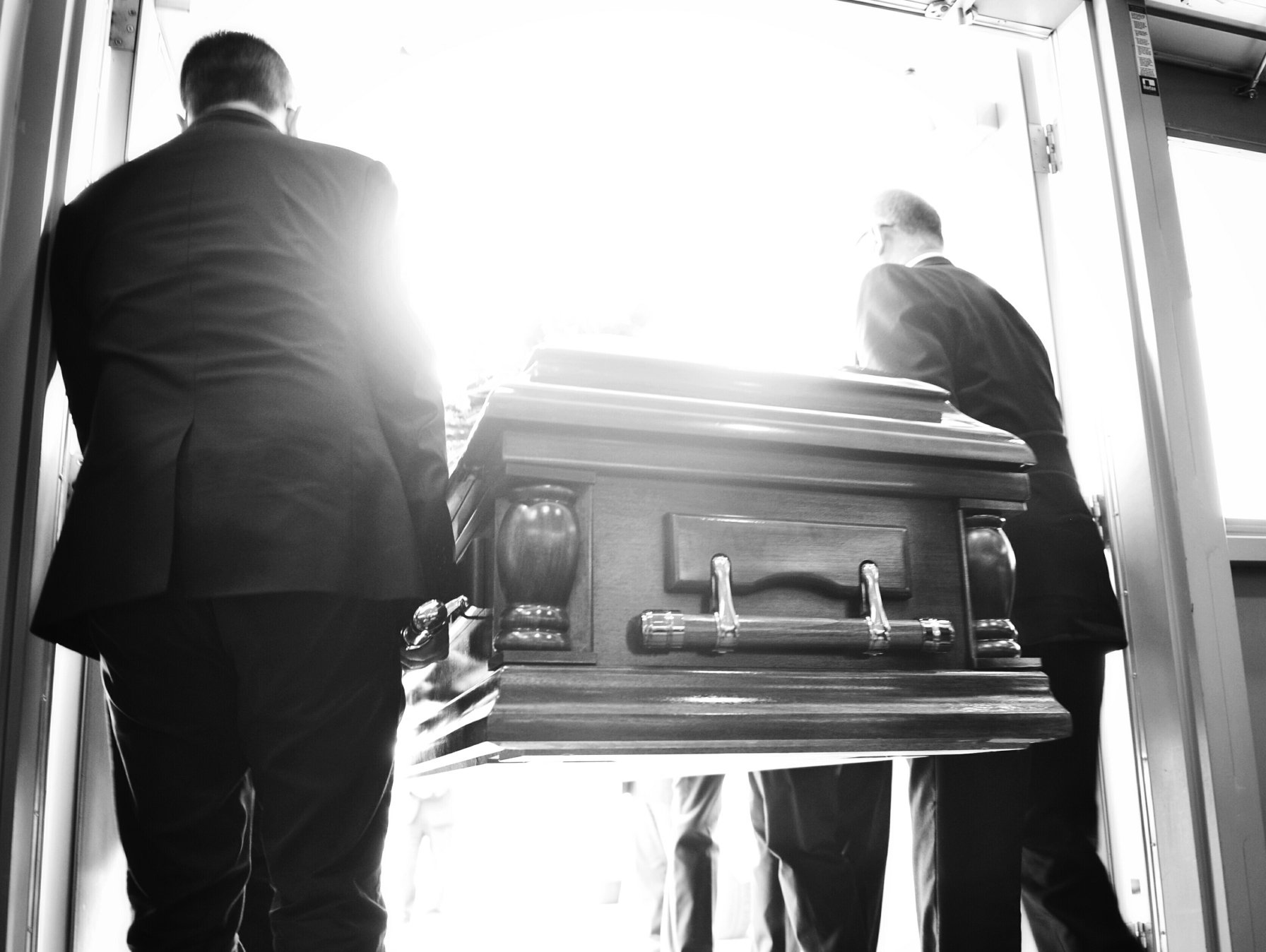 Photo de plusieurs hommes portant un cercueil à la main