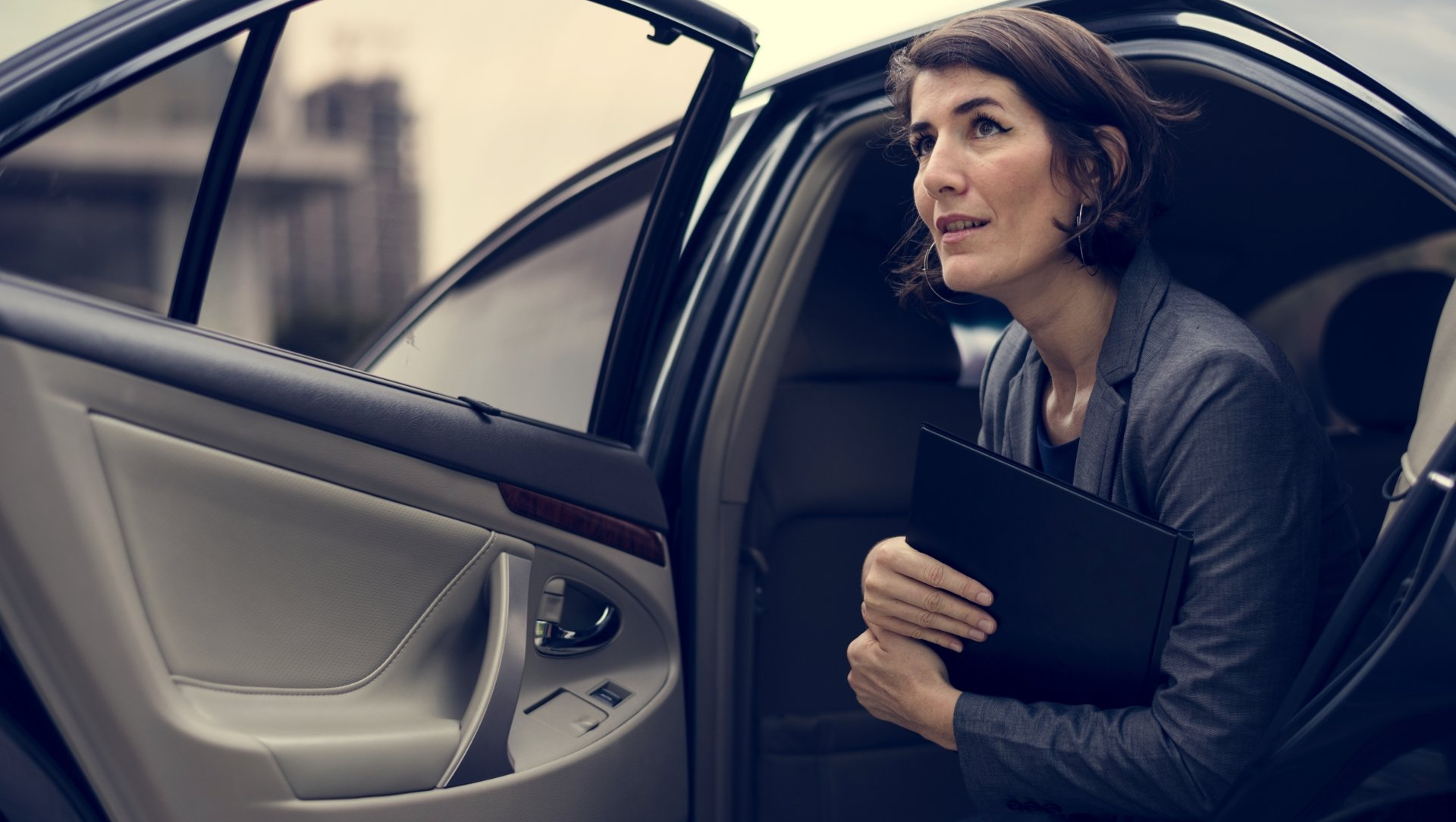 Photo d'une femme sortant d'une voiture noire