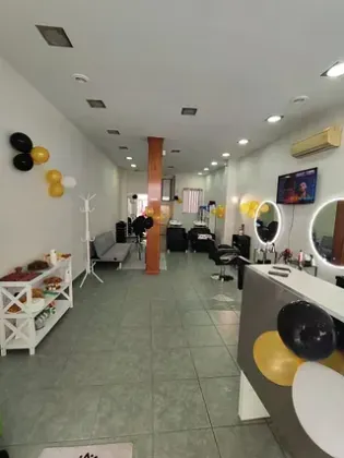 Un largo pasillo en una peluquería con globos en la pared.
