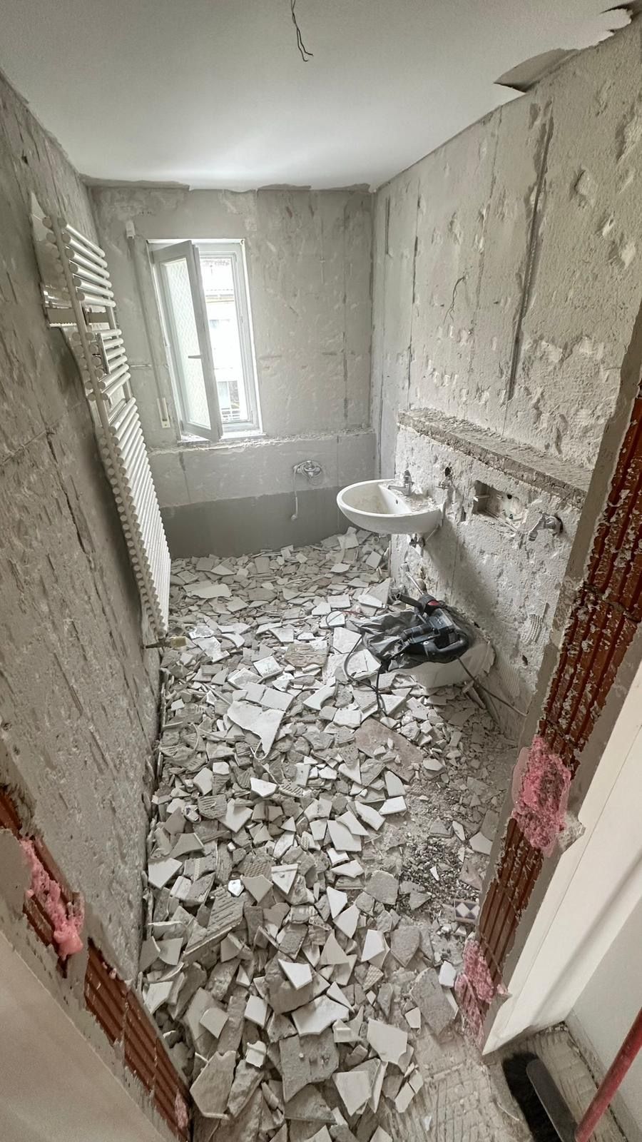 Badezimmer ohne Fliesen an der Wand mit einem Abbruch Werkzeug.