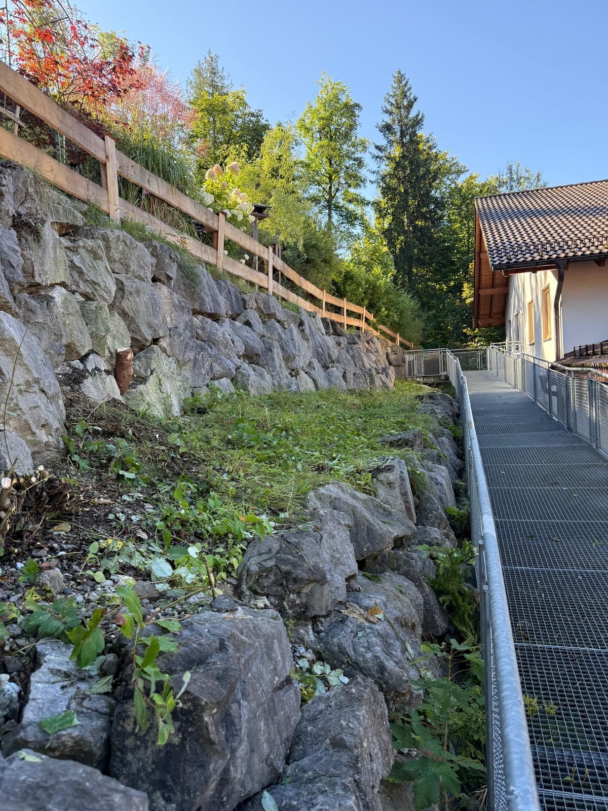 Gartenmauer aus Stein mit hölzernem Geländer