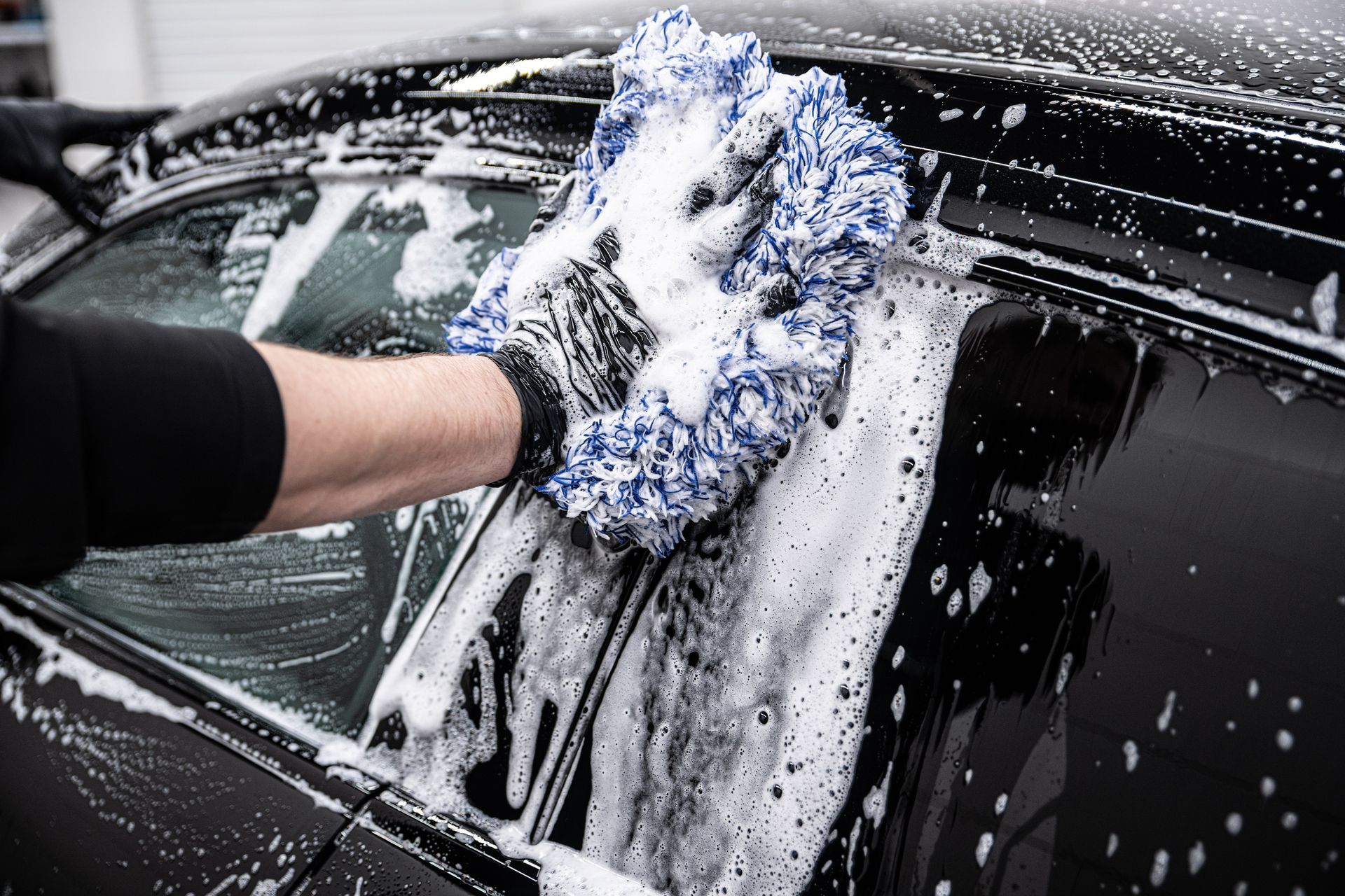 Un homme nettoyant une vitre de voiture