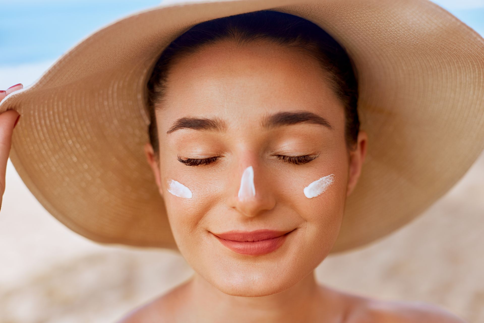 Une femme avec de la crème solaire sur le visage.