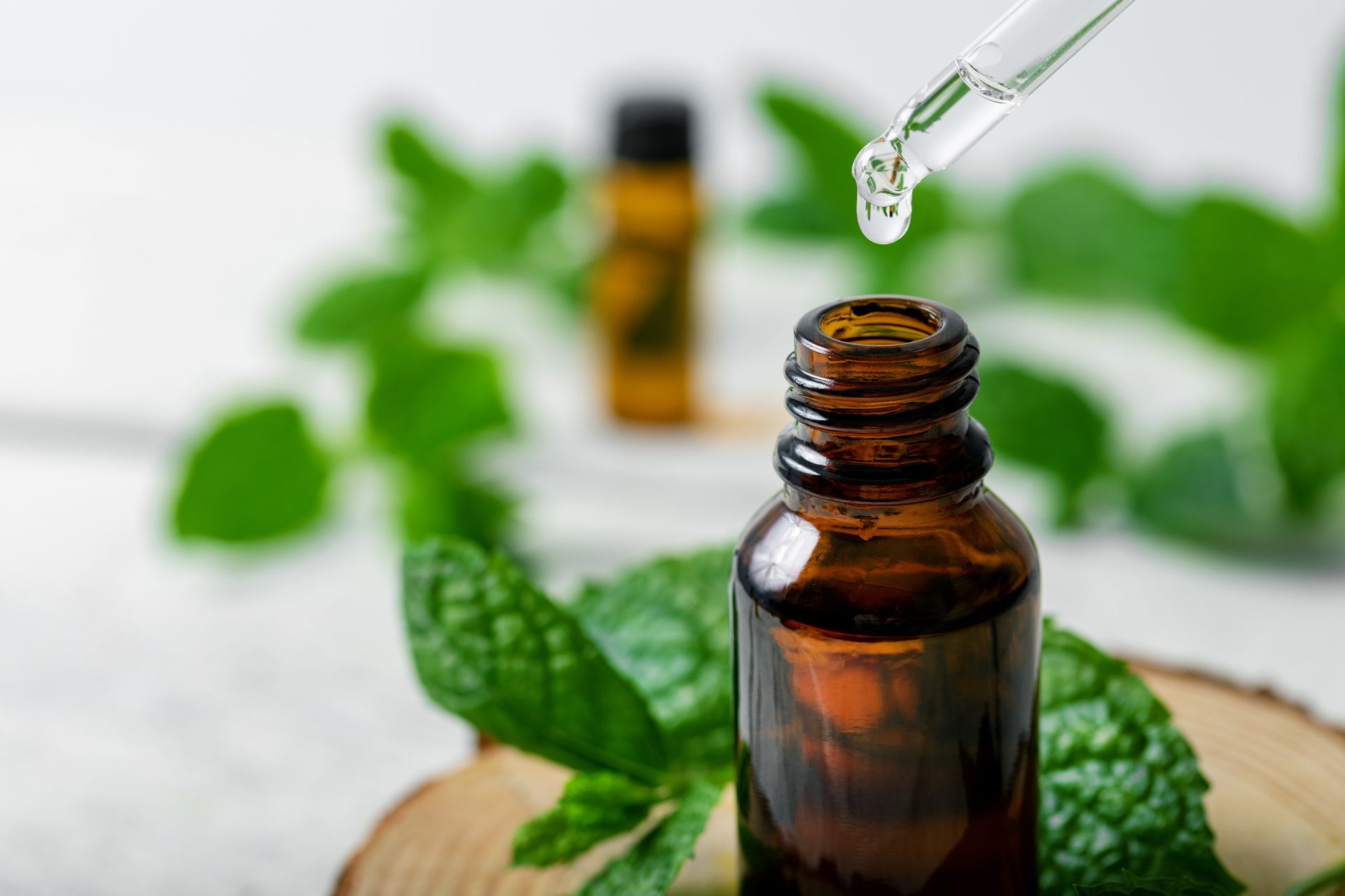 Une pipette au-dessus d'un flacon d'aromathérapie.
