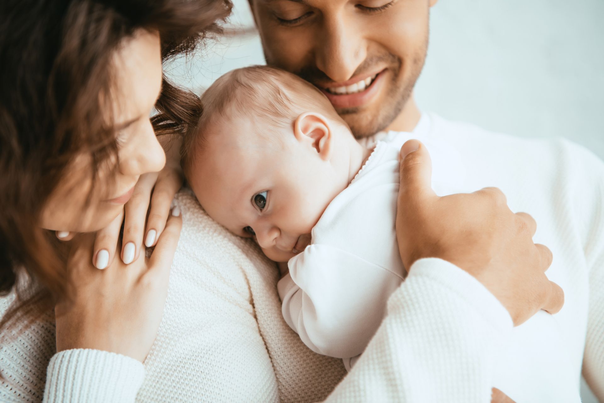Un bébé dans les bras de ses parents.