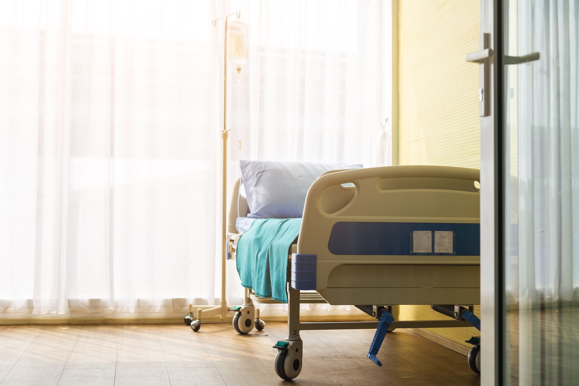 Un lit médicalisé près d'une fenêtre.