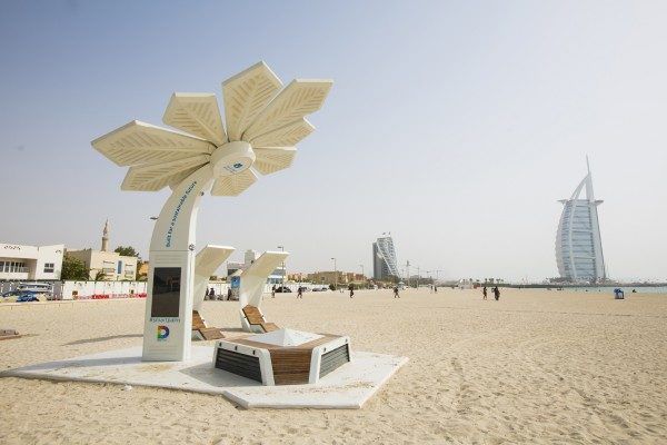 Un panneau solaire en forme de fleur est posé sur une plage de sable.