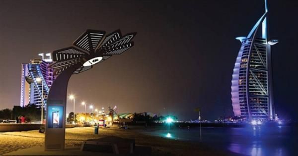 Un panneau solaire en forme de fleur est posé sur une plage de sable.