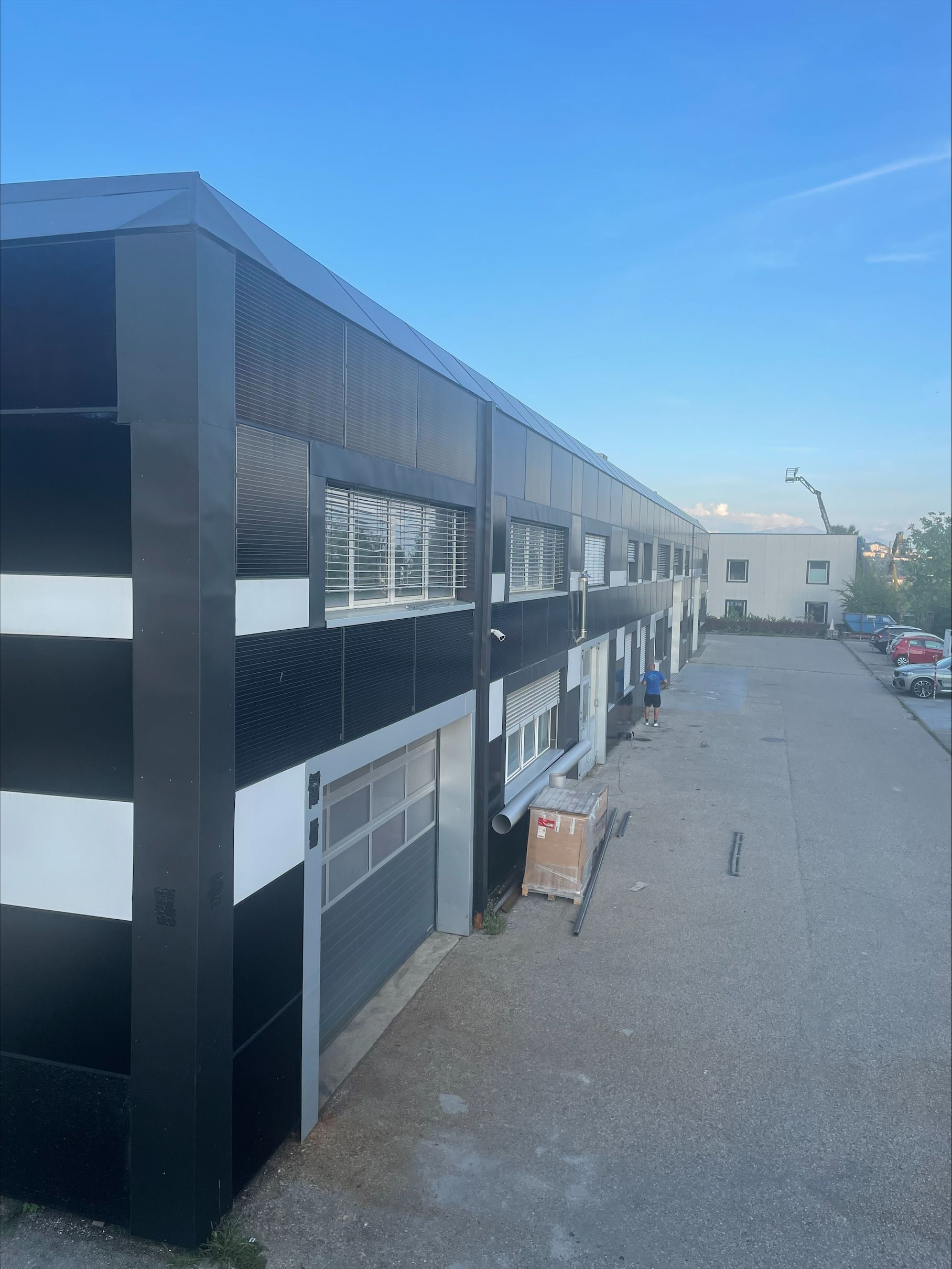 Un bâtiment noir et blanc avec beaucoup de fenêtres et de panneaux solaires sur la façade