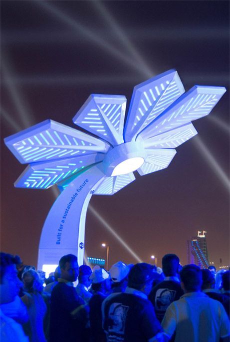 Une foule de personnes est rassemblée autour d'un présentoir en forme de fleur