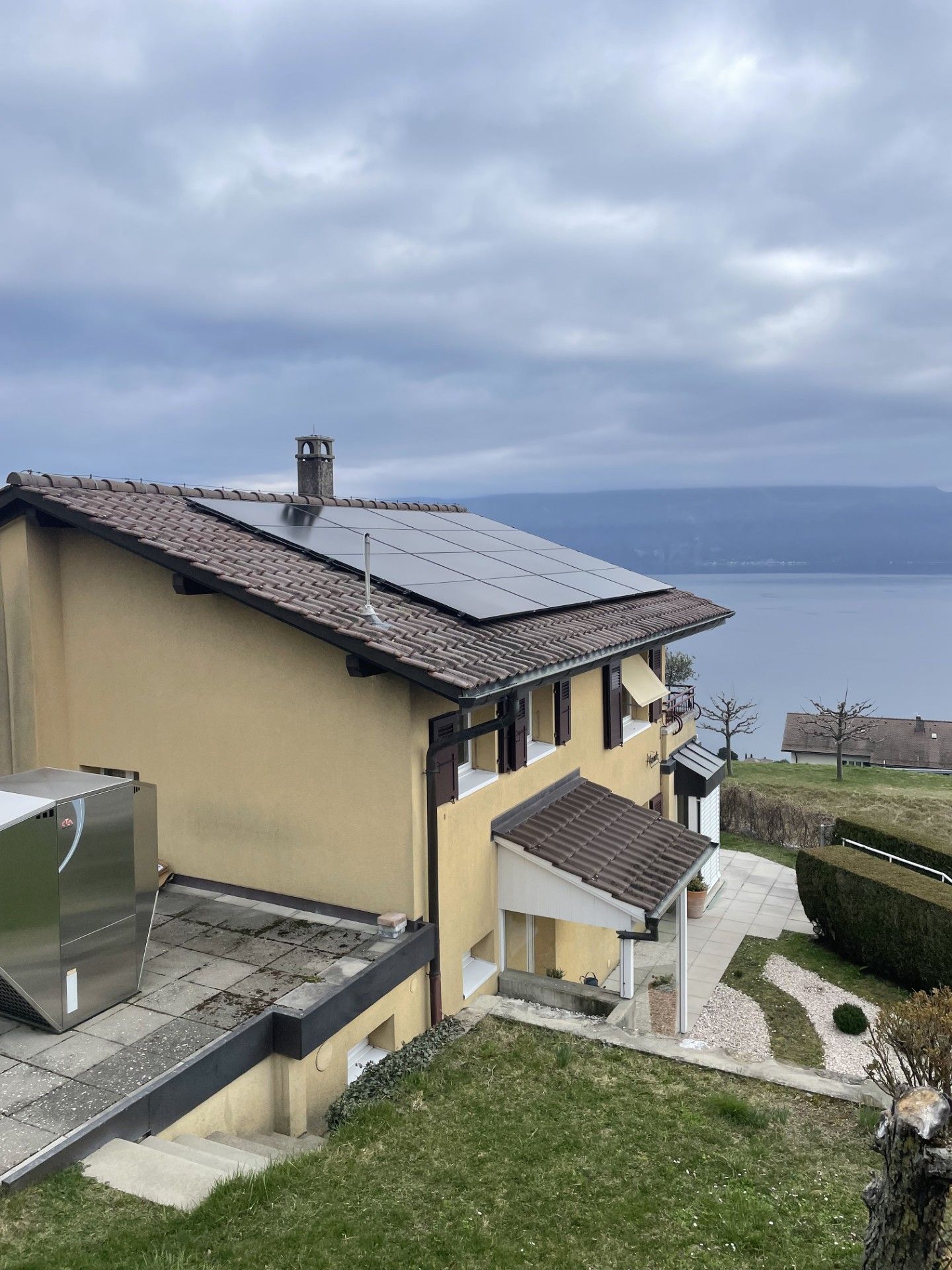 Une maison avec des panneaux solaires sur le toit et une vue sur l'océan.