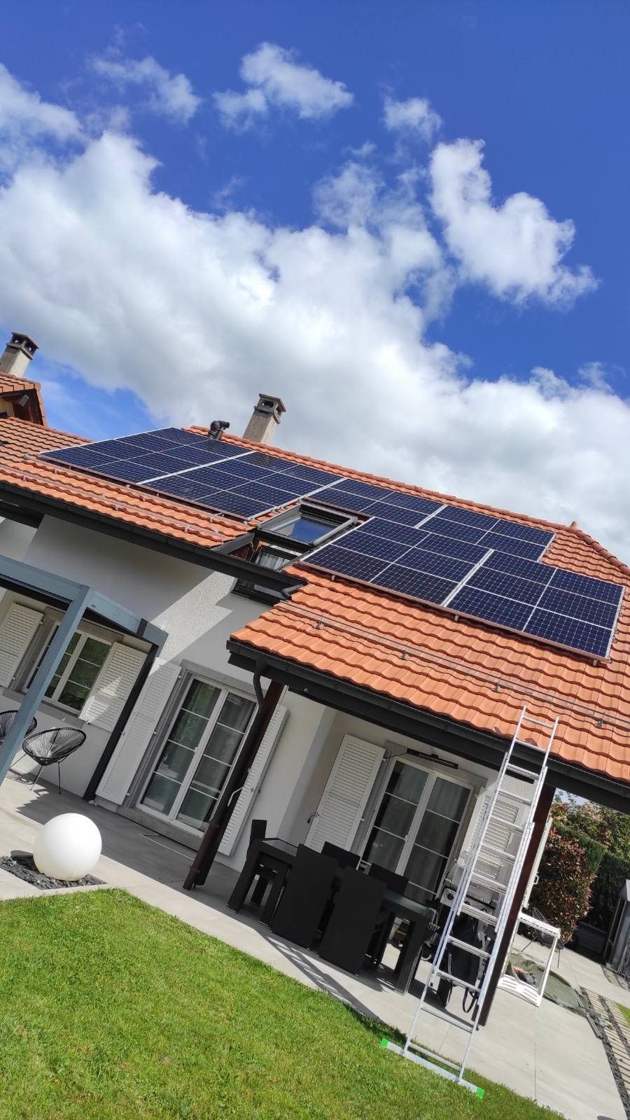 Une maison avec beaucoup de panneaux solaires sur le toit.
