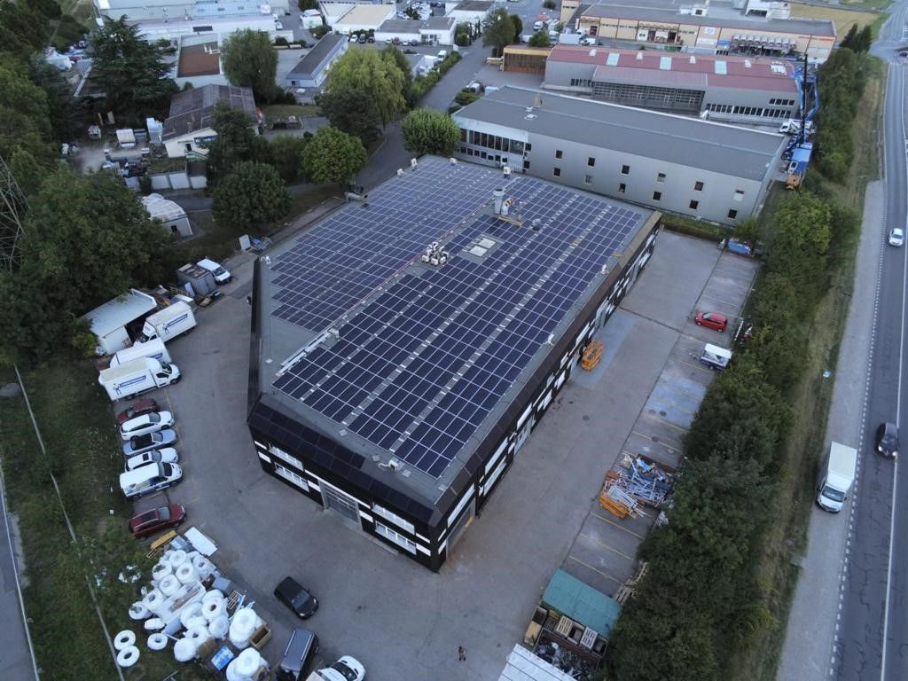 Une vue aérienne d'un grand bâtiment avec des panneaux solaires sur le toit