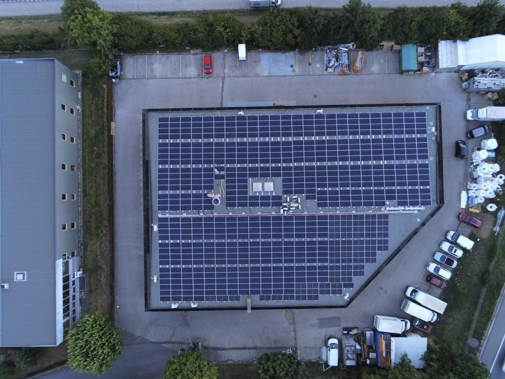 Une vue aérienne d'un grand bâtiment avec des panneaux solaires sur le toit.