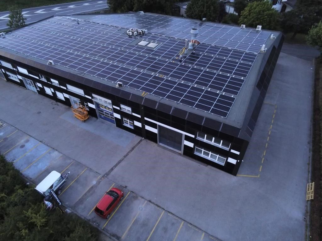 Une vue aérienne d'un grand bâtiment avec des panneaux solaires sur le toit.