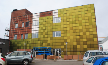 Un bâtiment avec beaucoup de panneaux solaires colorés sur la façade