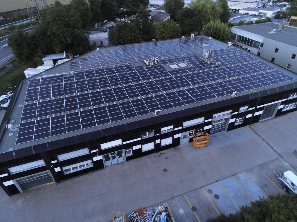 Une vue aérienne d'un grand bâtiment avec des panneaux solaires sur le toit.