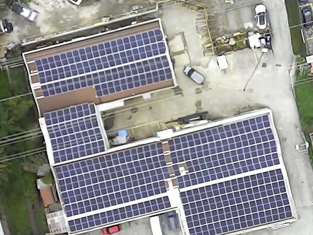 Une vue aérienne d'un bâtiment avec des panneaux solaires sur le toit.