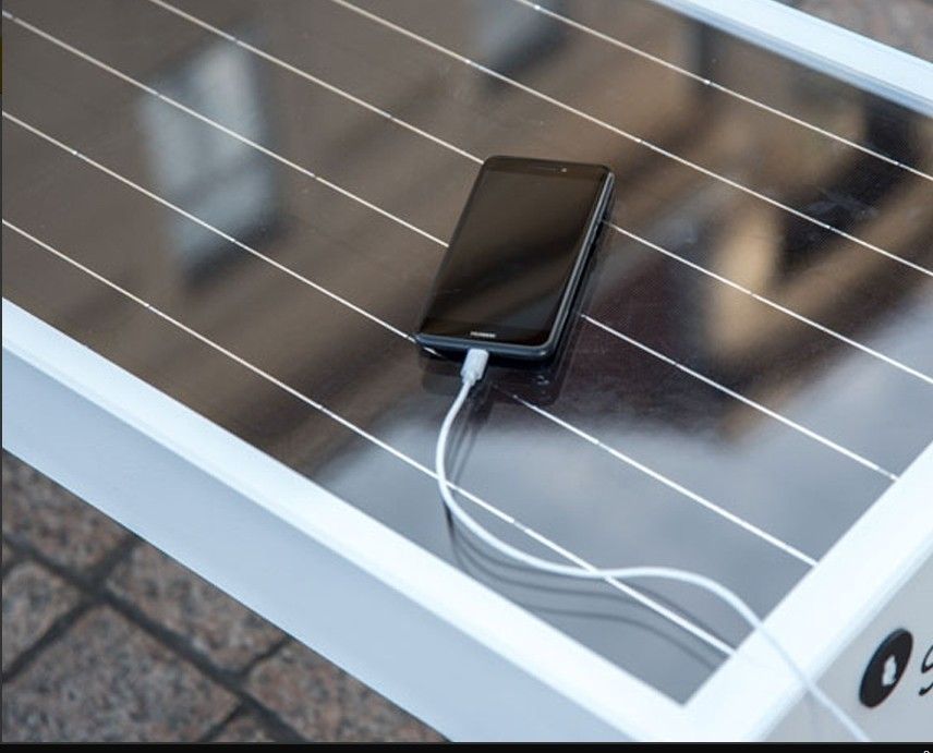 Un téléphone portable est branché sur un banc solaire