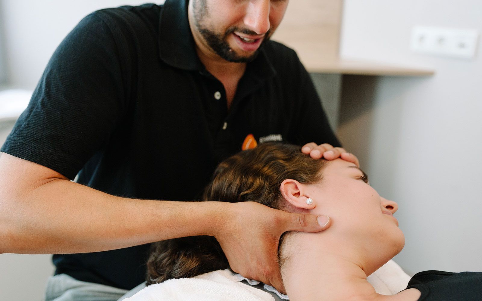 Ein Mann gibt einer Frau eine Nackenmassage.