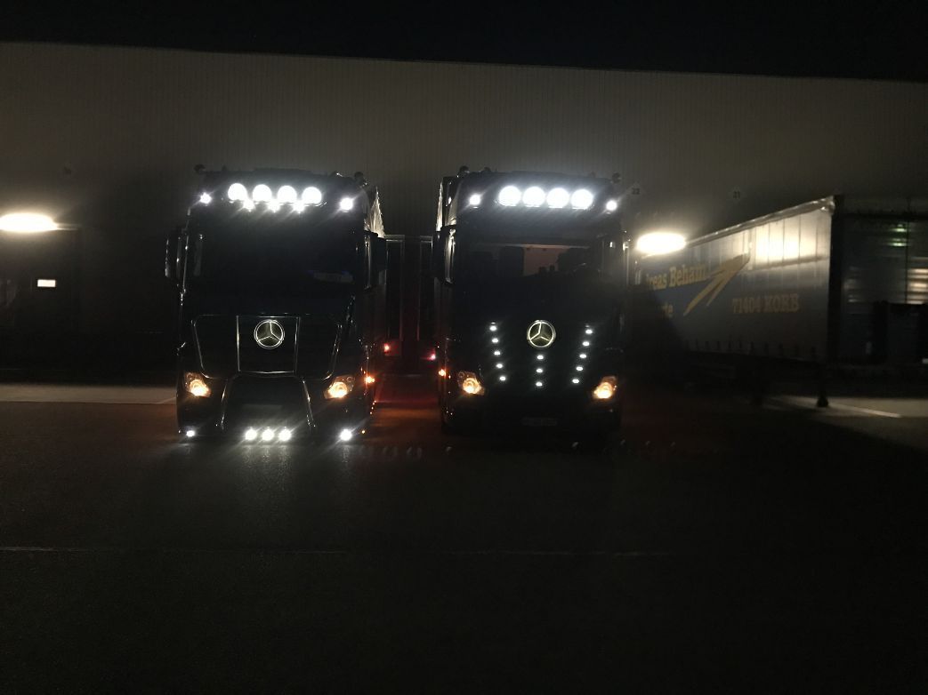 zwei beleuchtete Lkw bei Nacht