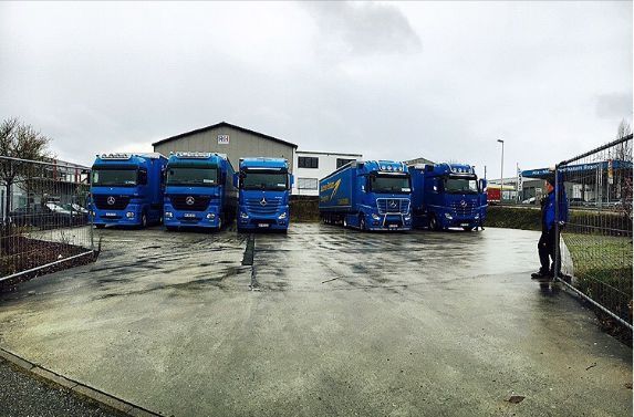 parkende Lkws vor Lagerhalle