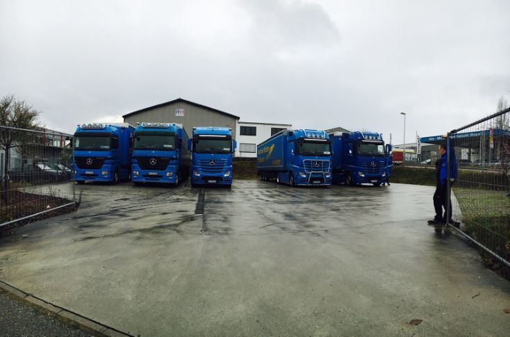 parkende Lkws vor Lagerhalle