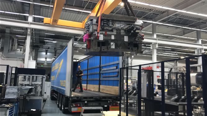 Güter werden in Ladefläche von Lkw gehoben