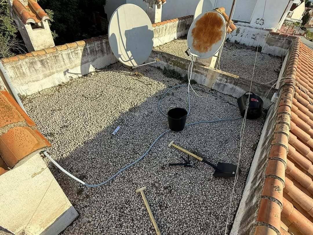 Hay una antena parabólica en el tejado de un edificio.
