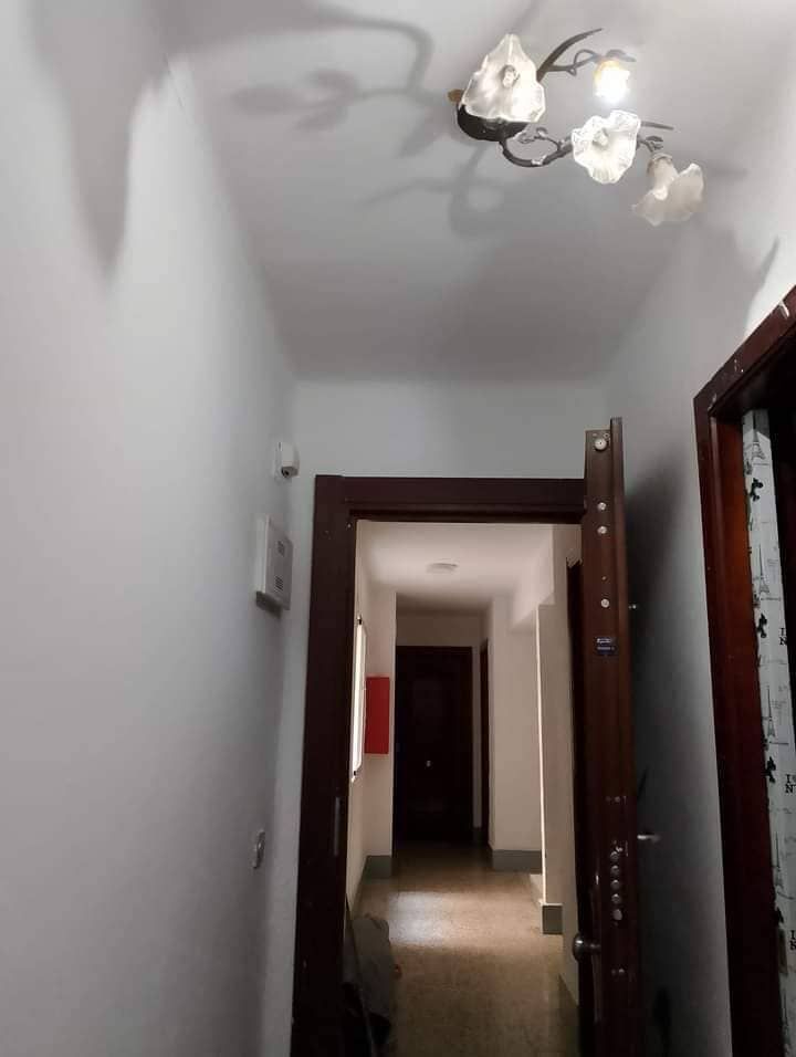 Un pasillo con una lámpara de araña colgando del techo.