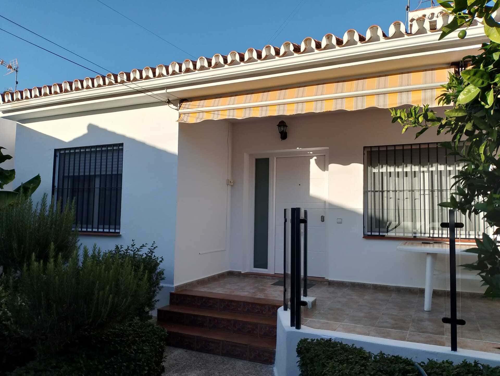 Una casa blanca con un toldo amarillo en el techo